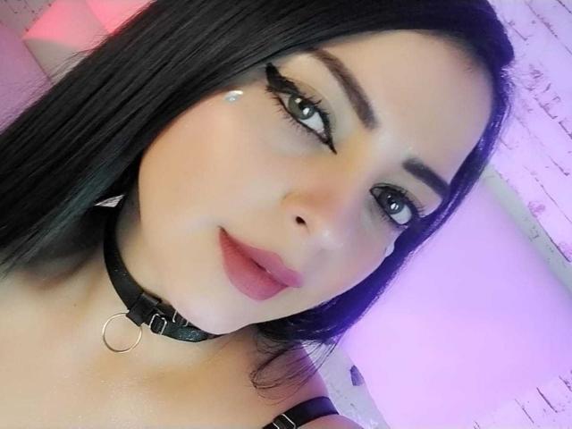 LilithAmoth tiene la piel pálida, el cabello negro, los ojos verdes, delineador de ojos alado, un diamante en la mejilla, labios rosados, y lleva un collar de cuero negro con un anillo..