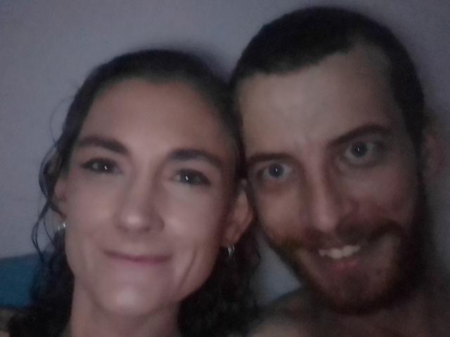 BoertJies with a smile, has dark curly hair and green eyes, next to a bearded BoertJies with a mustache, short brown hair, and blue eyes. Both are shirtless.