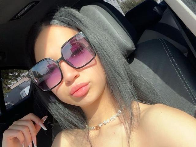 A minimalist digital illustration of a stylized, ornate letter "A" in a soft pinkish-red gradient. The letter has a slightly raised, textured surface with subtle shadows.