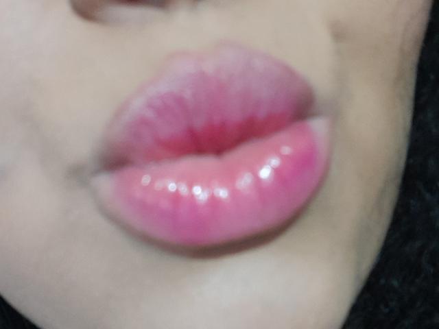MelannieCarter's glossy pink puffy ass lips are centered in the shot, with a slightly blurred background and visible part of her chin. Her lips are shiny and plump.