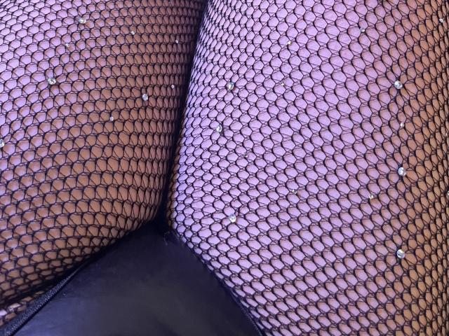 ShantallParis's ass in black fishnet stockings with small white studs, showing a tight, mesh pattern covering her butt and upper thighs, creating a provocative and textured look.