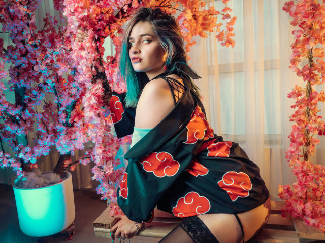 MaiaThunder with teal hair, black off-shoulder kimono, red cloud pattern, black lace stockings, sitting on bench, surrounded by pink and orange cherry blossoms, looking to the side.