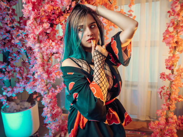 MaiaThunder with teal hair, fishnet glove, and black floral dress, finger to lips, hand in hair, pink cherry blossoms, soft light, looking to side, sexy, cute.