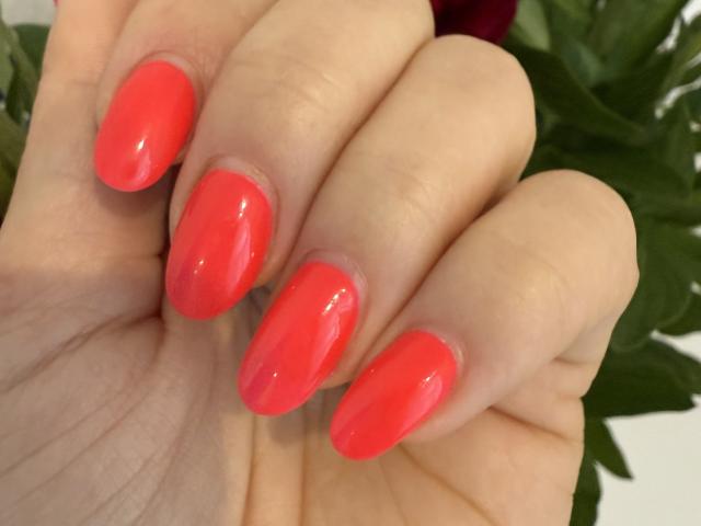Stefanni's shiny, hot pink, glossy nails are prominently displayed in the image. Her fingers are slightly curled, showing off her bright, polished, sexy-looking nails.