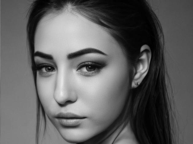 Black-and-white portrait of Miliaana with serious expression, dark eyebrows, subtle eyeliner, long straight hair, small ear piercing, and smooth skin. Her tits are not visible.