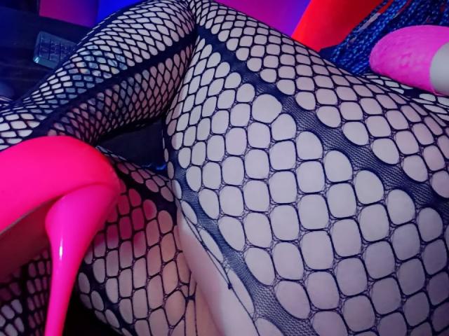 DalilaMusa's ass in black fishnet stockings, pink high heels, hexagonal pattern, visible crotch, pinkish-blue lighting, sexy, seductive, curvy, provocative.