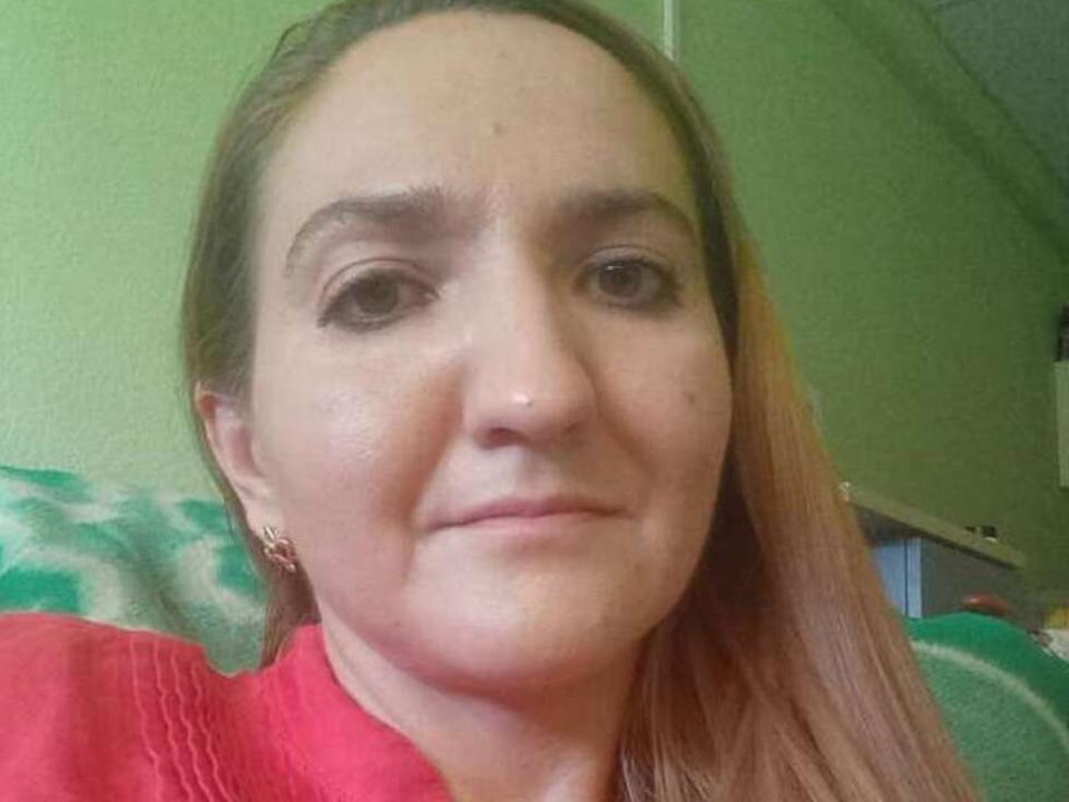 EstrellaWalters has light brown hair, brown eyes, and is wearing a red shirt with a subtle pattern. She's smiling with small earrings and a slight blush on her face.