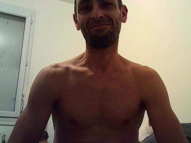 A flat, minimalist illustration of a coat of arms. The arms are centered, with a bold, white design on a dark background. The style is clean and simple.