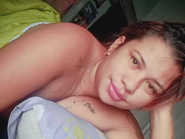 La photo de KathinLeighton, où elle est topless, montre ses épaules nues, ses yeux marron et son rouge à lèvres rose, ainsi qu'un petit tatouage sous sa poitrine gauche et un collier. Ses cheveux bruns sont légèrement en désordre..