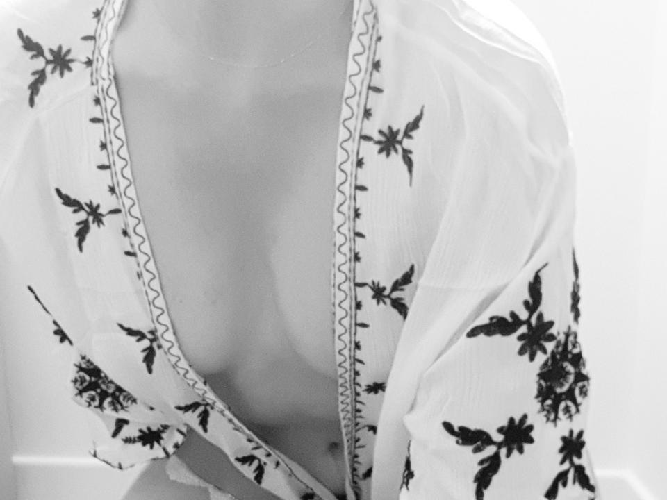 Ndaurc69's tits are visible through a deep V-neck floral kimono, with black patterns on white fabric, showing a bit of cleavage, in a black-and-white photo.