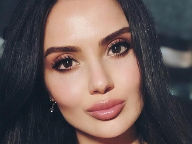 JuicySexyGirl has smooth, shiny brown lips, dark long hair, and brown eyes with thick eyelashes. She's sporting a cute, sexy, and confident look.
