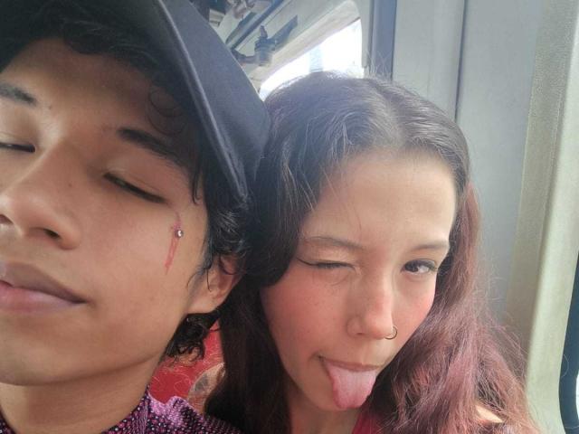 Il selfie di RoxanAndNoah: RoxanAndNoah con un piercing al naso, che fa l'occhiolino, ha una piccola cicatrice sulla guancia; Noah con lunghi capelli castani, la lingua fuori, con un anello al naso..