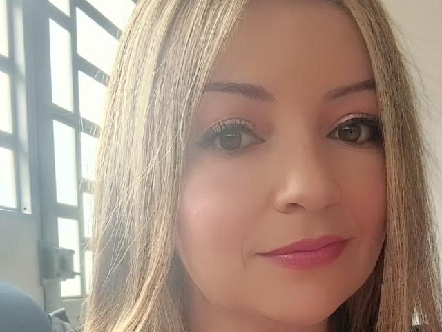 NatalyHami has blonde hair, pink lipstick, and a slight smile with her eyes looking forward. She's got a cute face with a light skin tone and subtle makeup.