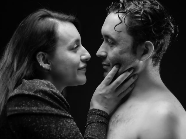 Black-and-white photo of Jeremmy and Stacy. Jeremmy's shirtless, Stacy's hand on his neck, looking into each other's faces. Stacy's sparkly jacket, Jeremmy's wet, curly hair.