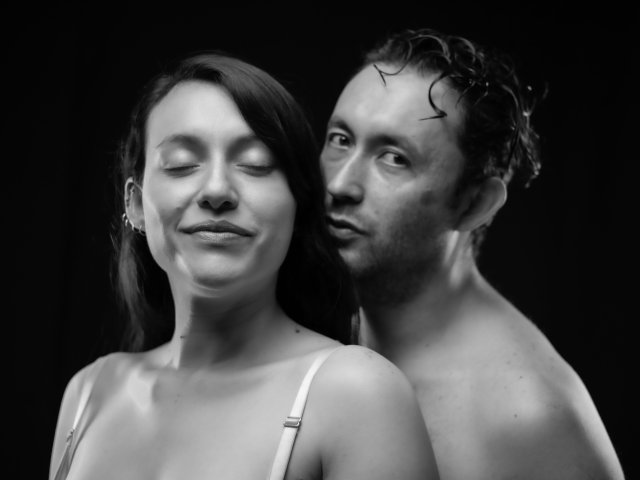 Black-and-white photo of Jeremmy with wet, curly hair and Stacy, with closed eyes and a slight smile, both shirtless, Stacy's small tits visible, Jeremmy's nose slightly pointed.