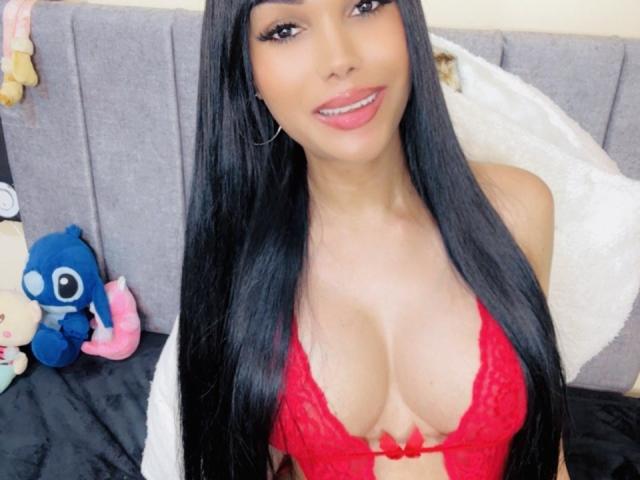 VanezzaTss has long black hair, brown eyes, thick eyebrows, long eyelashes, pink lipstick, and a smile showing white teeth. She's wearing a red top.