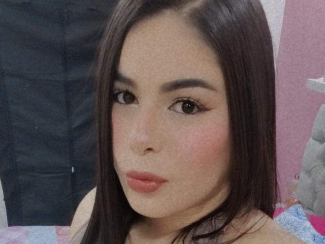MagicLadies has straight brown hair, full pink lips, and brown eyes with long eyelashes. Her face has a slight blush, and she's looking at the camera with a neutral expression.