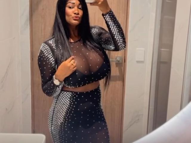 DesirreBlack has huge tits, wearing a sheer black mesh top with white polka dots, and a matching mesh skirt, taking a mirror selfie with long black hair.