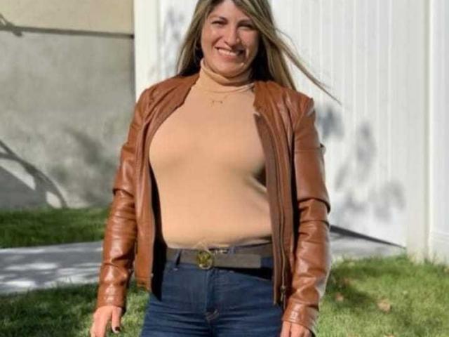 A digital illustration of a red and white medieval-style coat of arms with a central, upright, red, stylized letter "V". Bold, flat colors. Minimalist, geometric design. No texture.