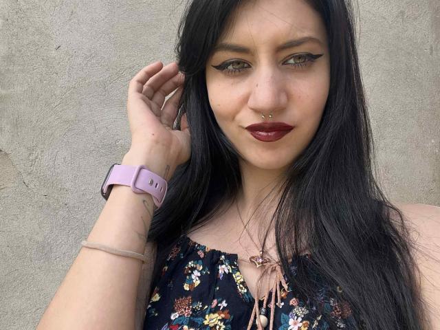 CristalFoxy ha i capelli neri, gli occhi marroni, un piercing al naso e eyeliner, con piccole lentiggini sul viso. Indossa una canotta bianca e maniche nere..