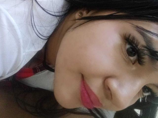 Il viso di Sofia Rutso, con i capelli scuri, le lunghe ciglia, le labbra rosa e la pelle abbronzata, in un selfie. Il suo naso è leggermente all'insù e sorride in modo discreto. Il suo seno non è visibile..