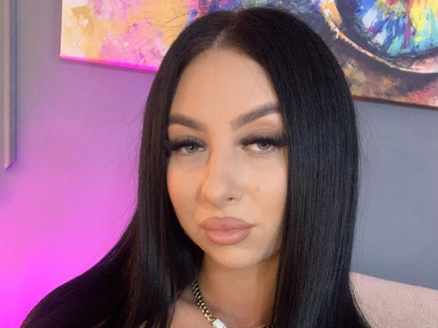 LexyVoss tiene el pelo largo y negro, cejas pobladas y pestañas gruesas con delineador de ojos. Lleva un collar dorado y tiene labios rosados. Sus glúteos no son visibles..