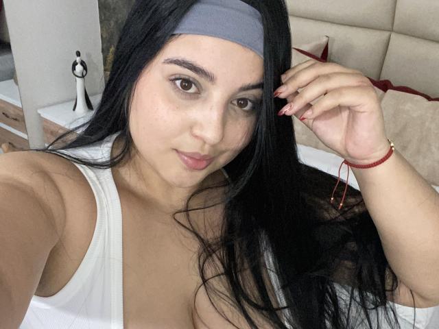 ShinyMurpy a de longs cheveux noirs, un bandeau gris, et porte un débardeur blanc. Elle met en valeur ses seins avec un bracelet rouge à sa main droite..