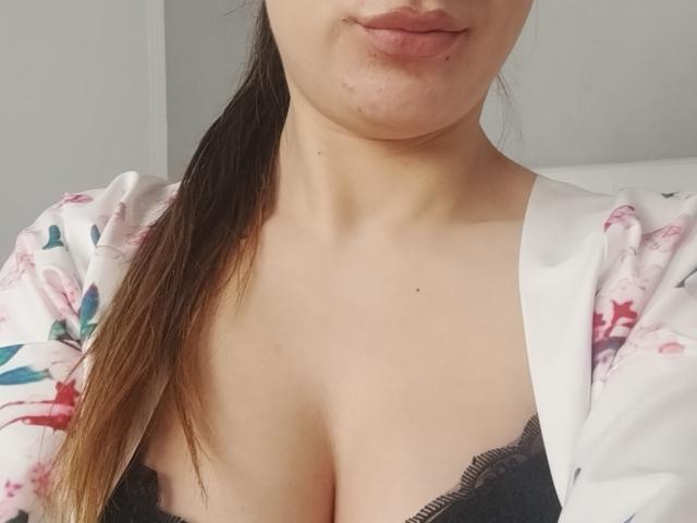 JuliaHuntis with light skin, pouty lips, and brown ponytail, wearing a floral kimono, exposing her black lace bra and her big tits.