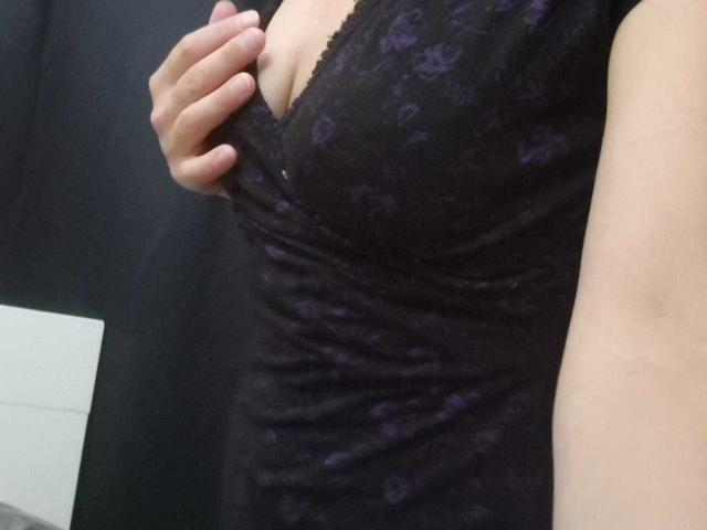 FrancaiseAline's hand is pulling down a black lace dress to reveal her large, soft, purple-patterned tits. Her light skin is visible on the right side of the image.