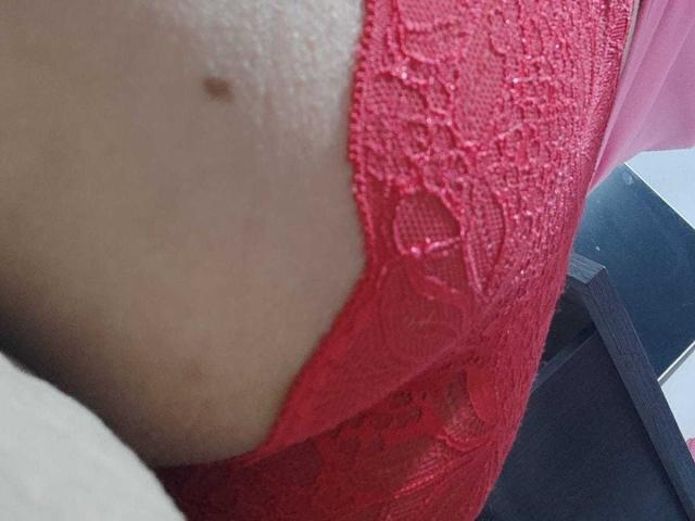 EmmaLaurent's red lace lingerie is against her pale skin, showing a small brown mole on her side, with her curved butt slightly visible in the close-up shot.