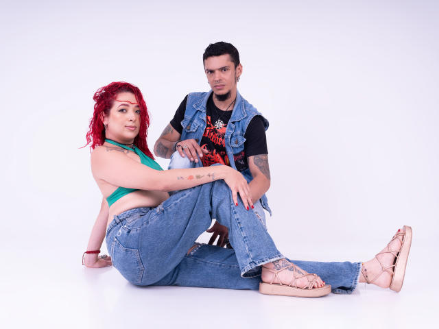 Abby y Vincent, ella con cabello rizado rojo, una blusa verde, jeans azules y sandalias, sentados con las piernas extendidas, mostrando sus senos. Vincent, con cabello negro, un chaleco de mezclilla y una camiseta con diseño, está arrodillado..