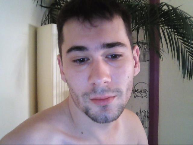 Ethan69 has short brown hair, light skin, a small goatee, and is shirtless with a neutral expression. He has a small mole on his left cheek.