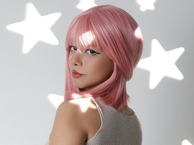 LilyElfie with pink bob, looking over shoulder, wearing white mesh top, shiny skin, star shadows, and long eyelashes, showing off her ass.