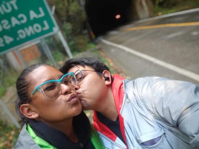JuliaxRosee and her boyfriend are kissing, both wearing glasses and winter jackets, with her green scarf and his red one. Her tits are slightly visible under her jacket.