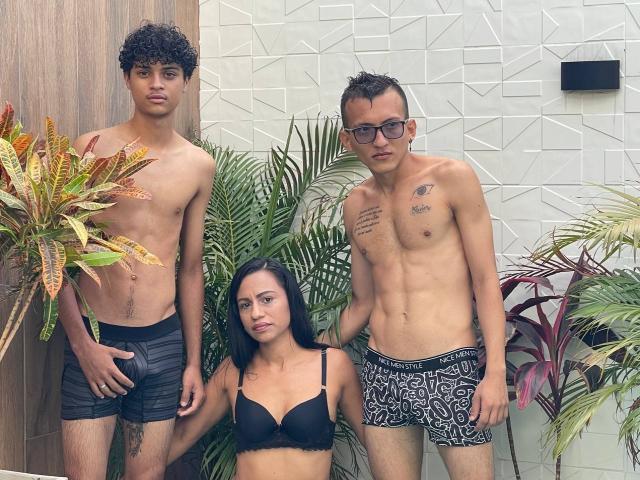Three WorldSexxxADS standing; WorldSexxxADS with curly dark hair, black shorts, slim build, small penis; WorldSexxxADS with glasses, tattoos, black-and-white shorts, slim build, small penis; WorldSexxxADS with black bra.