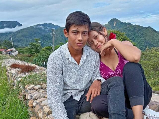 FantasyasCompartidas69, with short black hair and a grey shirt, sits beside FantasyasCompartidas69, who has brown hair, a pink top, and black pants, resting her head on his shoulder.