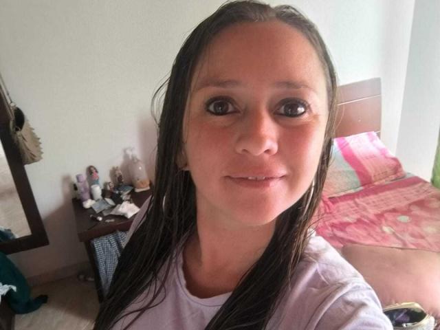 CelesteStorm has wet brown hair, brown eyes, and a slight smile. She's wearing a white shirt, and her tits are small. Her nose is slightly upturned.