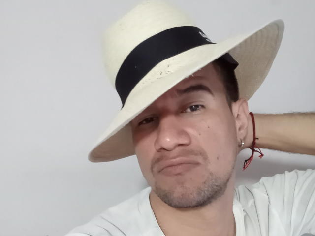 AxelNavas69, wearing a white straw hat with a black band, has a smug face, light skin, short dark hair, a red earring, and a white shirt.