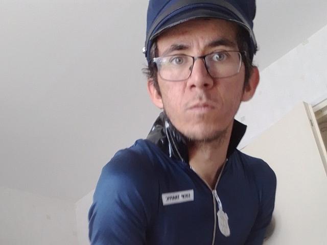 Bricebd has a serious face, wearing glasses, a blue cap, and a matching blue zip-up shirt with a name tag. He's got a slight mustache and a goatee.