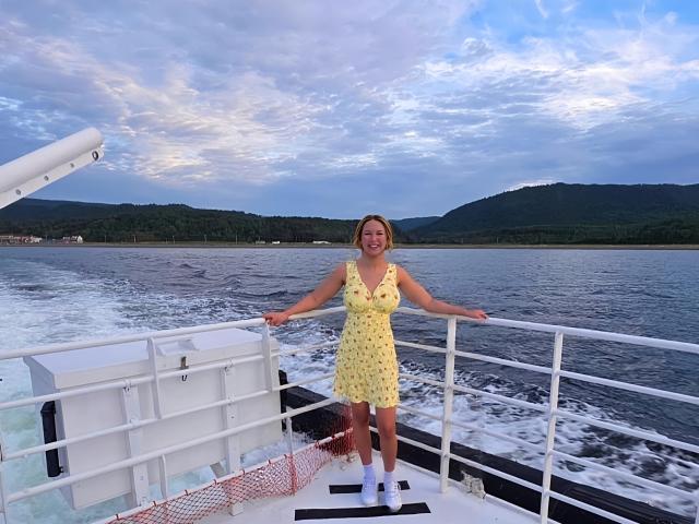 Digital illustration of a flag with a red cross on a white background, centered and slightly tilted. A small yellow and red emblem is in the bottom right.