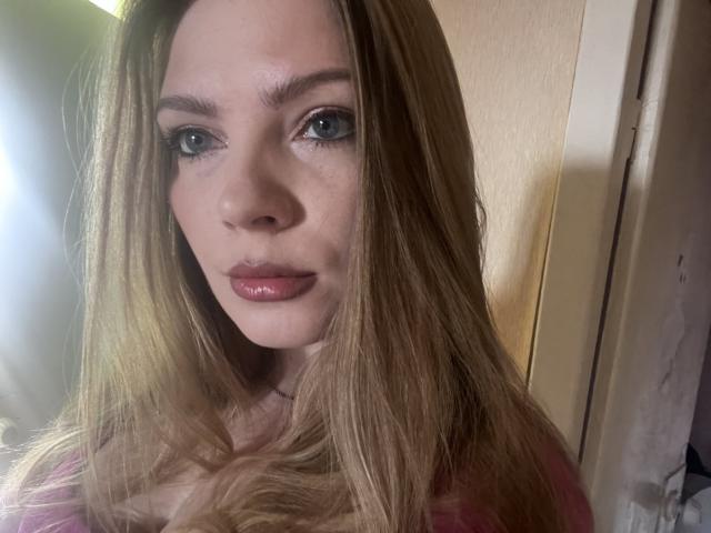 VickElsie has long, straight blonde hair, blue eyes, and shiny pink lips. She's wearing a pink top, and the photo is a clear, up-close selfie.
