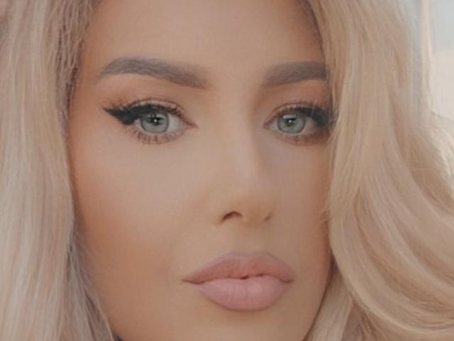 OndinaNoir's face with blonde hair, thick eyebrows, green eyes, black eyeliner, and pink lipstick. Her tits aren't visible. Her ass isn't visible. Her pussy isn't visible.
