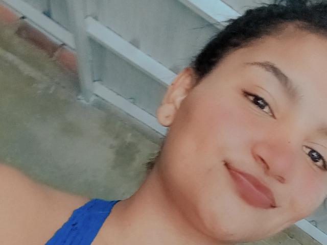 SusanaDiaz has a cute smile, brown eyes, and a light brown complexion with dark hair. She's wearing a blue top, showing her bare shoulders and a bit of her neck.