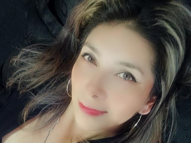 Michelle Dumont tiene una cara bonita, con ojos marrones, piel clara y lápiz labial rosa. Lleva aretes de aro y tiene el cabello castaño oscuro con reflejos rubios..