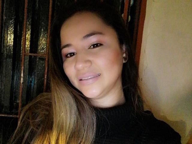 JasmineWade has a cute face with light brown skin, brown eyes, and a subtle smile. She's wearing a black turtleneck, and has a lip piercing and small earrings.