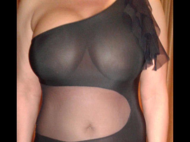 Sophia01-hot wearing a sheer black one-piece that reveals her large tits and a cut-out showing her belly button, with a black ruffle on the side.