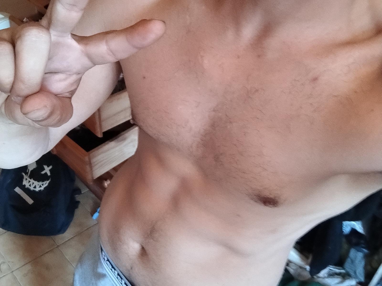 Sexyfr69's shirtless, hairy chest with a visible nipple, making a peace sign with a slightly tanned, toned, and hairy upper body. Wearing gray underwear.