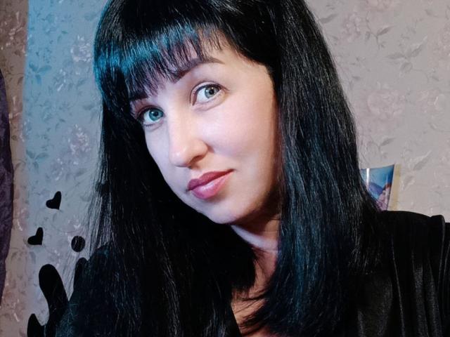 JillSilvies ha i capelli neri, lisci, lunghi fino alle spalle e con la frangia, la pelle chiara, gli occhi azzurri e il rossetto rosa. Indossa una maglietta nera e guarda leggermente a sinistra..