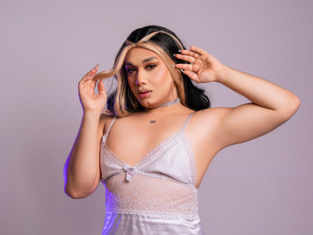 PamelaAdamms with blonde and black hair, wearing a white lace lingerie top, hands in hair, choker, tattoo on chest, soft purple lighting, upper body, sexy.