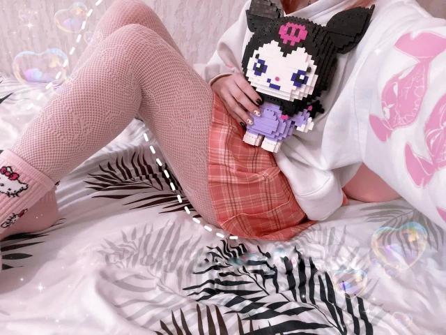 AngelOfGrom-hot in white sweatshirt, pink plaid skirt, fishnet stockings, holding pixel art cat toy, pink socks with cat, lying on zebra-patterned bed, bubbles around.